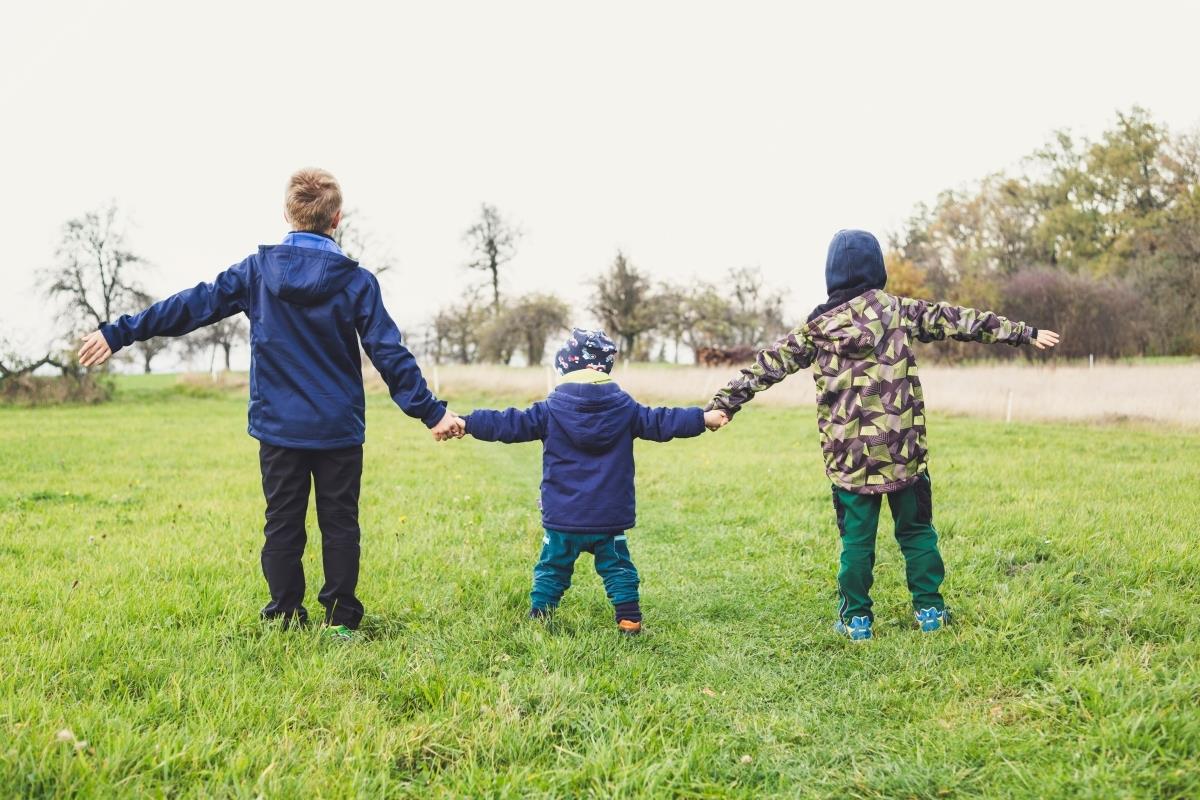 three kids holding hands