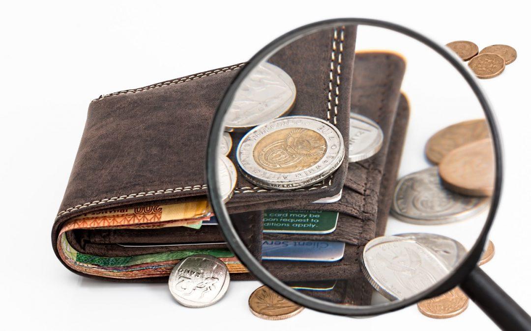 wallet with money through a magnifying glass